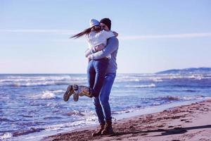 Loving young couple on a beach at autumn sunny day photo