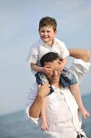 feliz padre e hijo se divierten y disfrutan del tiempo en la playa foto