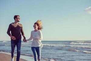 Loving young couple on a beach at autumn sunny day photo