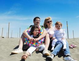 familia joven feliz divertirse en la playa foto