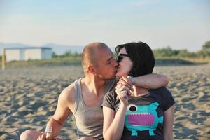 feliz pareja joven divertirse en la playa foto