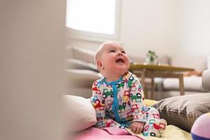 bebé recién nacido sentado en mantas de colores foto
