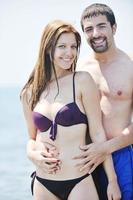 happy young couple have romantic time on beach photo