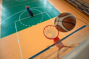 tow view photo of a war veteran playing basketball in a modern sports arena. The concept of sport for people with disabilities