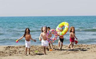 grupo infantil divertirse y jugar con juguetes de playa foto