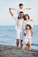 familia joven feliz divertirse en la playa foto