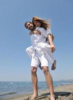 happy young couple have fun on beach photo