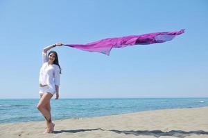 hermosa mujer joven en la playa con bufanda foto