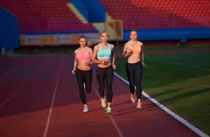 athlete woman group  running on athletics race track photo