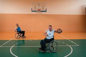 veteranos de guerra discapacitados en acción mientras juegan baloncesto en una cancha de baloncesto con equipo deportivo profesional para discapacitados foto