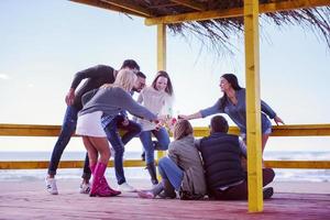 grupo de amigos divirtiéndose el día de otoño en la playa foto