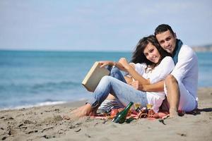 young couple enjoying  picnic on the beach photo