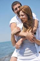 happy young couple have fun on beach photo