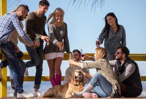 Group of friends having fun on autumn day at beach photo