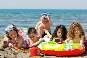 grupo infantil divertirse y jugar con juguetes de playa foto