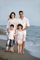 familia joven feliz divertirse en la playa foto