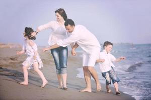 familia joven feliz divertirse en la playa foto