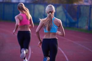 grupo de mujeres atletas corriendo en la pista de carreras de atletismo foto