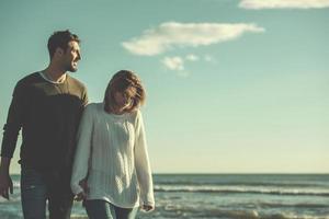 Loving young couple on a beach at autumn sunny day photo