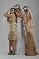 portrait of a three beautiful woman in wedding dress photo