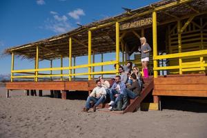 grupo de amigos divirtiéndose el día de otoño en la playa foto