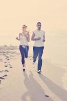 couple jogging on the beach photo