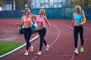 grupo de mujeres atletas corriendo en la pista de carreras de atletismo foto