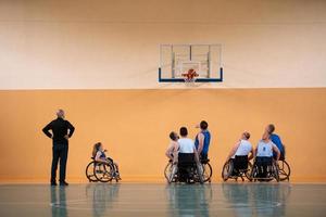 Disabled War veterans mixed race opposing basketball teams in wheelchairs photographed in action while playing an important match in a modern hall. photo