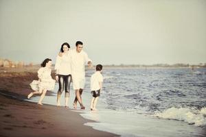 happy young family have fun on beach at sunset photo