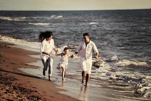 familia joven feliz divertirse en la playa foto