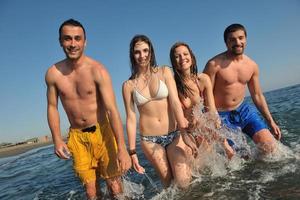 grupo de gente feliz divertirse y correr en la playa foto