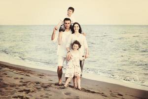 familia joven feliz divertirse en la playa foto