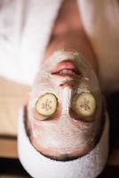woman is getting facial clay mask at spa photo