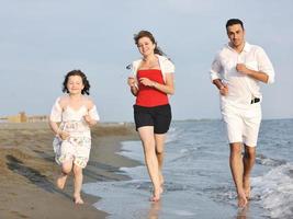 familia joven feliz divertirse en la playa foto