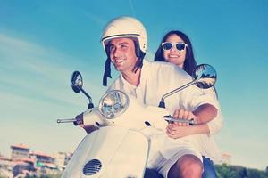 retrato de feliz pareja de amor joven en scooter disfrutando del verano foto
