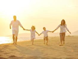 happy young family have fun on beach at sunset photo