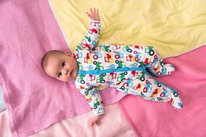 top view of newborn baby boy lying on colorful blankets photo