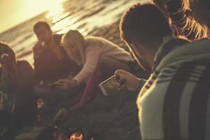 Friends having fun at beach on autumn day photo