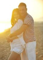 feliz pareja joven tiene tiempo romántico en la playa foto