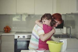 madre e hija jugando y preparando masa en la cocina. foto