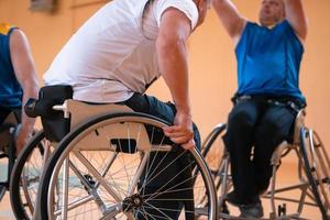 Close up photo of wheelchairs and handicapped war veterans playing basketball on the court