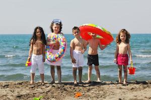 grupo infantil divertirse y jugar con juguetes de playa foto