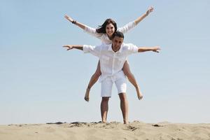 happy young couple have fun on beach photo