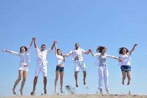 grupo de gente feliz divertirse y correr en la playa foto