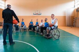 selector I explain new tactics to basketball players in wheelchairs, players sit in wheelchairs listening to the selector photo