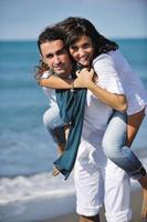 feliz pareja joven divertirse en la hermosa playa foto