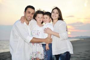 familia joven feliz divertirse en la playa foto