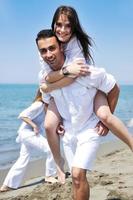 happy young couple have fun on beach photo