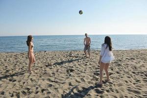 grupo de jóvenes divertirse y jugar voleibol de playa foto