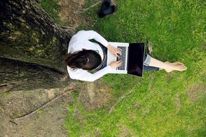 woman with laptop in park photo